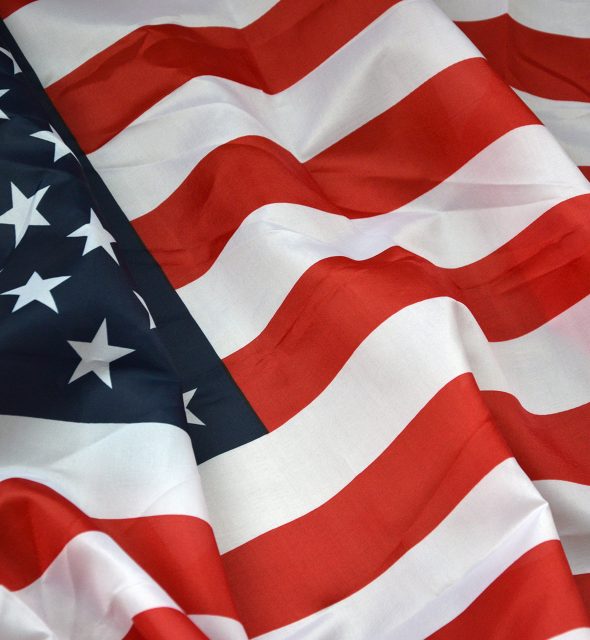 Closeup of American flag on plain background. Colorful waving horizontal US banner with stars and stripes